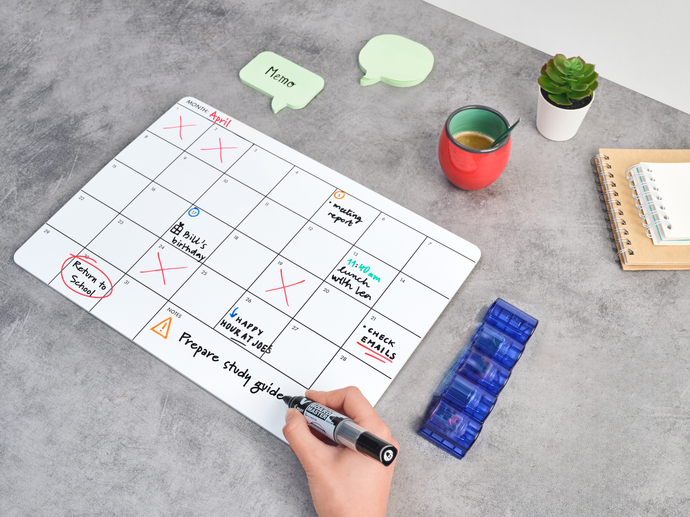 Hand writing monthly plans for April on a whiteboard using a black PILOT V Board Master marker