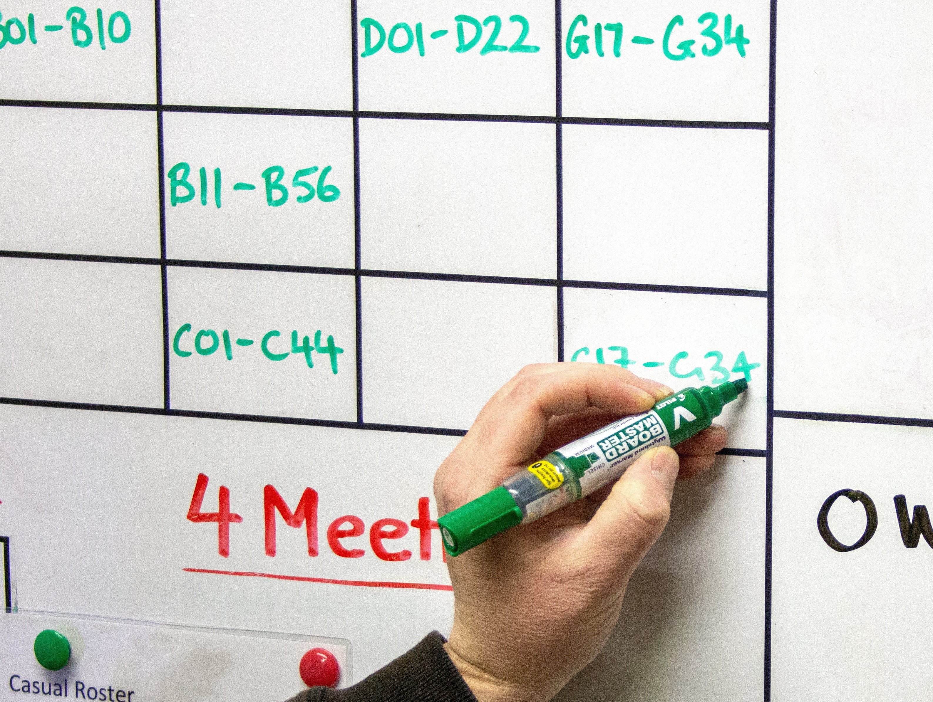 Hand writing on a whiteboard with a green PILOT V Board Master marker