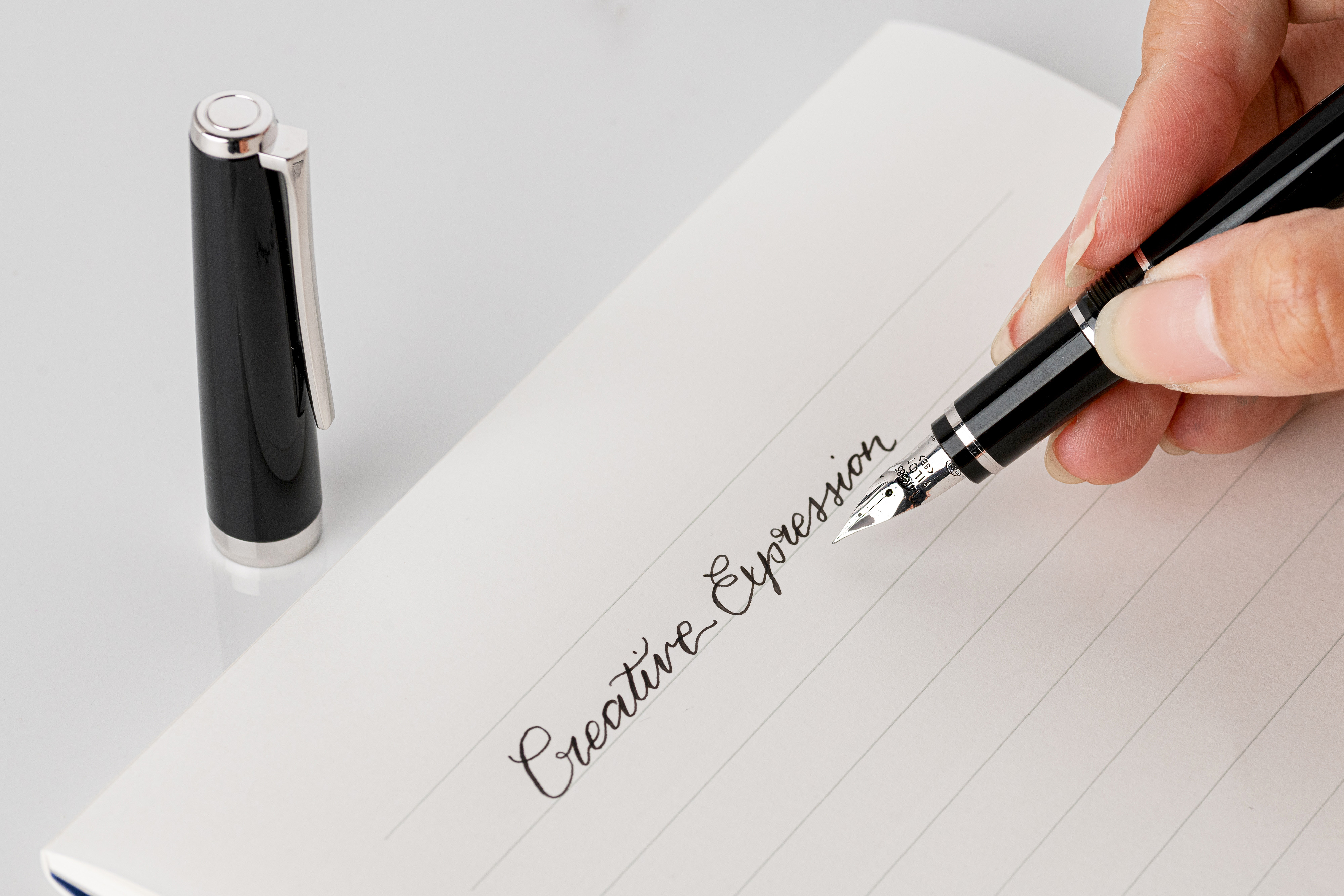 Writing the words 'Creative Expression' with the Falcon luxury foutain pen