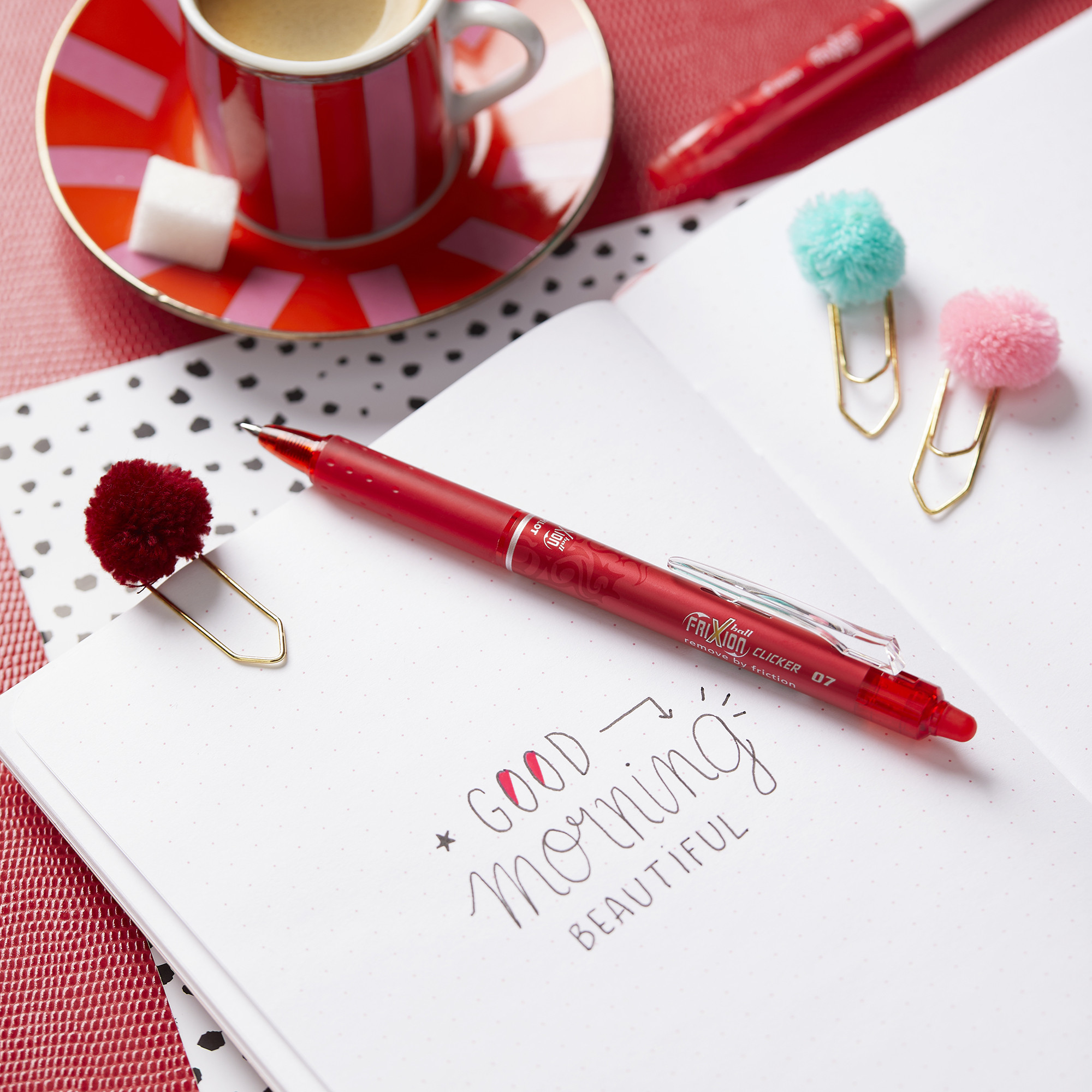 Red PILOT FriXion Erasable Clicker 0.7 drafting a greeting in a dotted notebook, writing a thank you note.