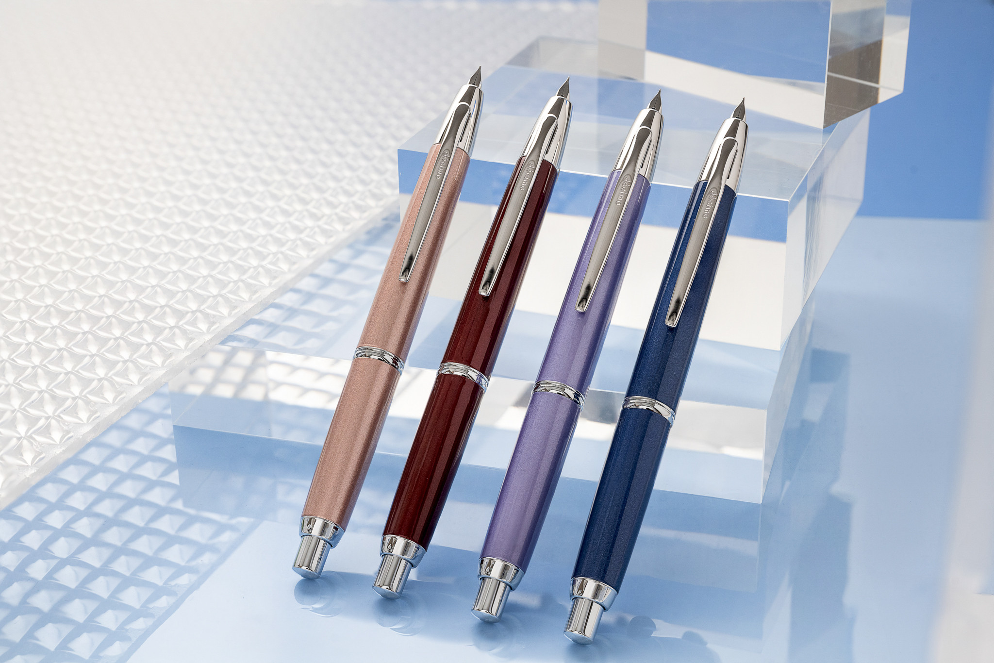 PILOT Capless Retractable Fountain Pens in champagne pink, red, violet, and dark blue, showcasing innovative retractable nib design and fine craftsmanship, a modern evolution of the fountain pen first patented by Petrache Poenaru in 1827
