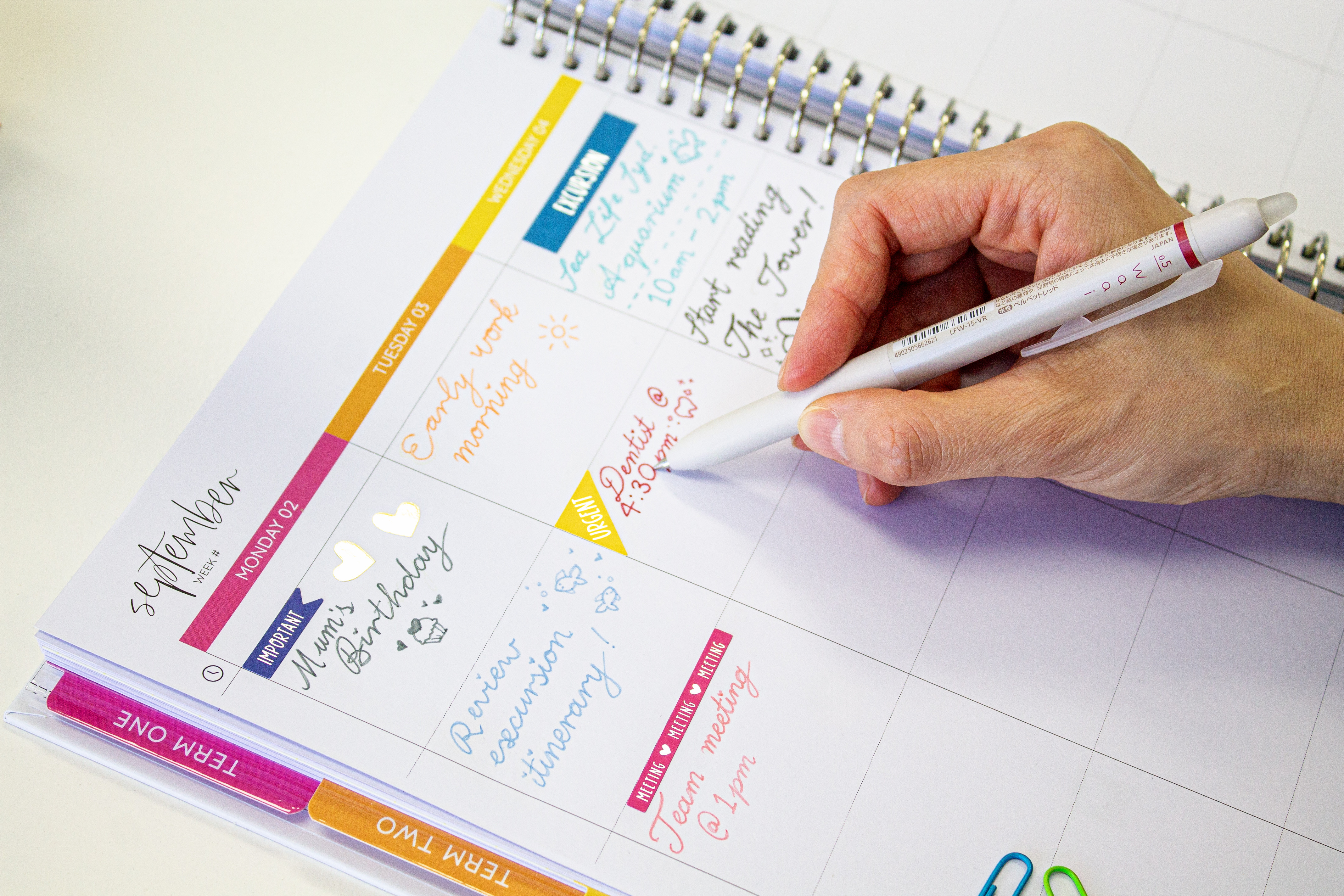 Desk setup with planner and PILOT FriXion pens comparing handwriting vs typing for weekly planning