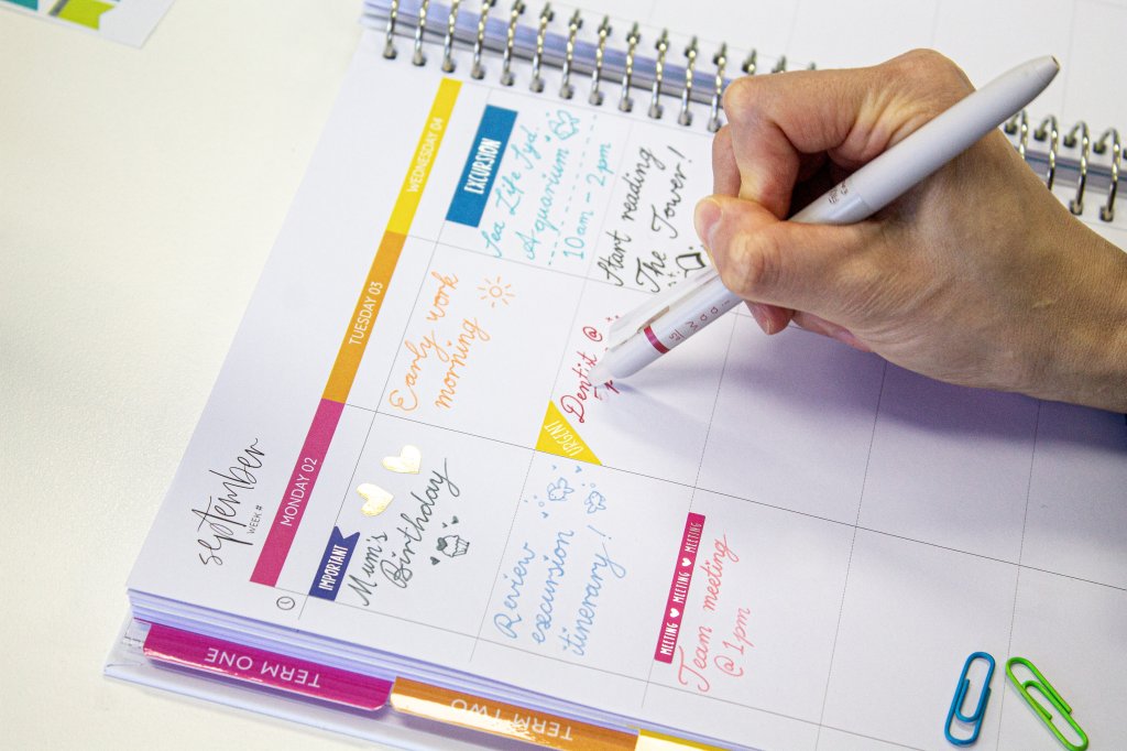 Handwriting in a colourful planner with a FriXion pen, one of the best pens for note taking and journaling.